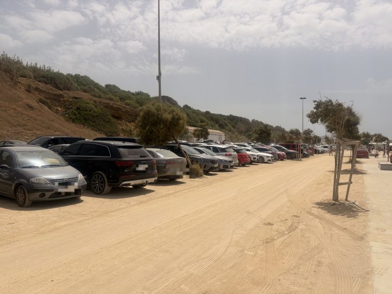 Coches aparcados en la zona de aparcamiento gratuito junto a la playa de Conil de la Frontera