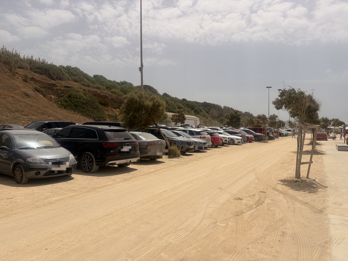 Coches aparcados en la zona de aparcamiento gratuito junto a la playa de Conil de la Frontera