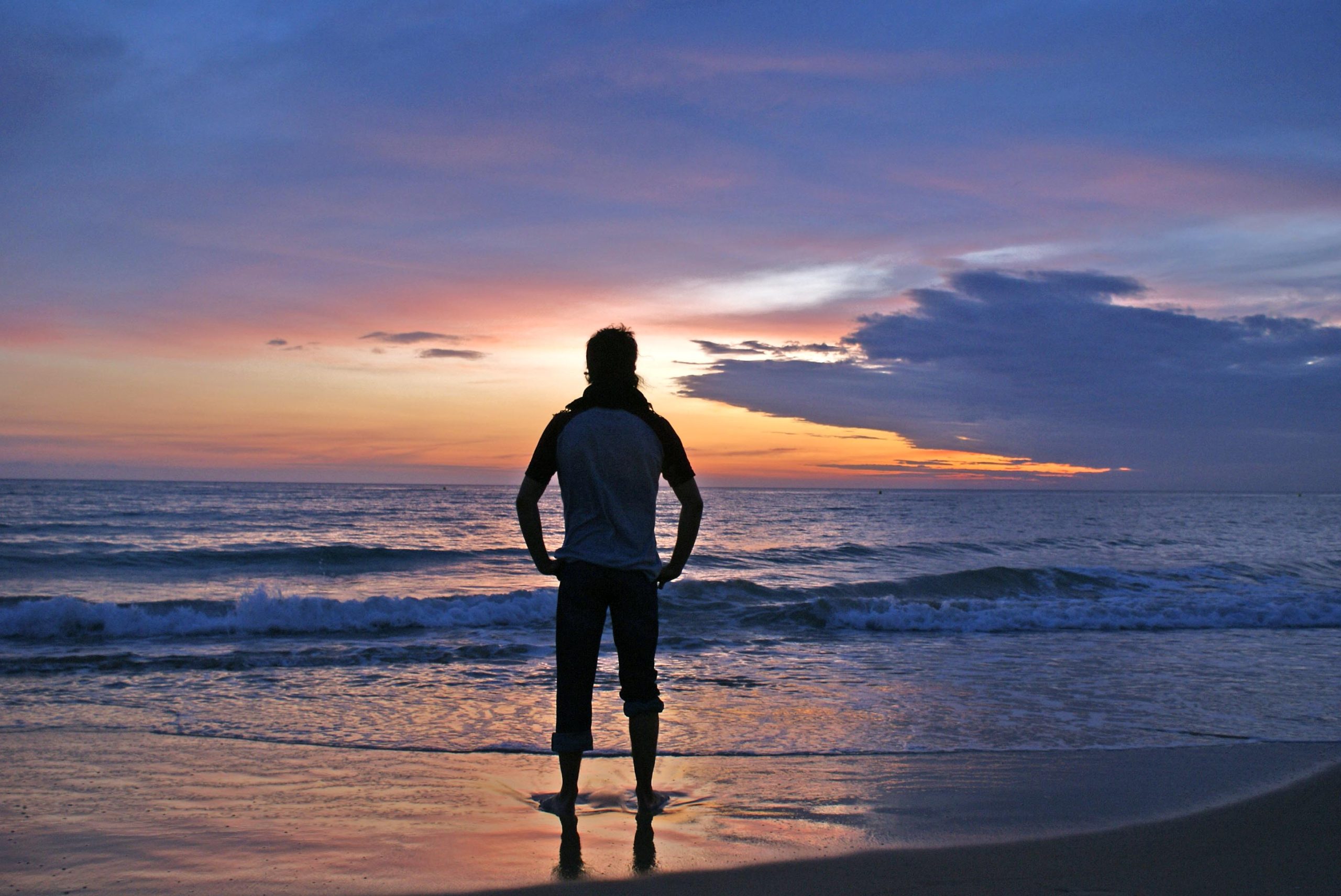Persona contemplando el atardecer sobre el mar en la playa de El Palmar