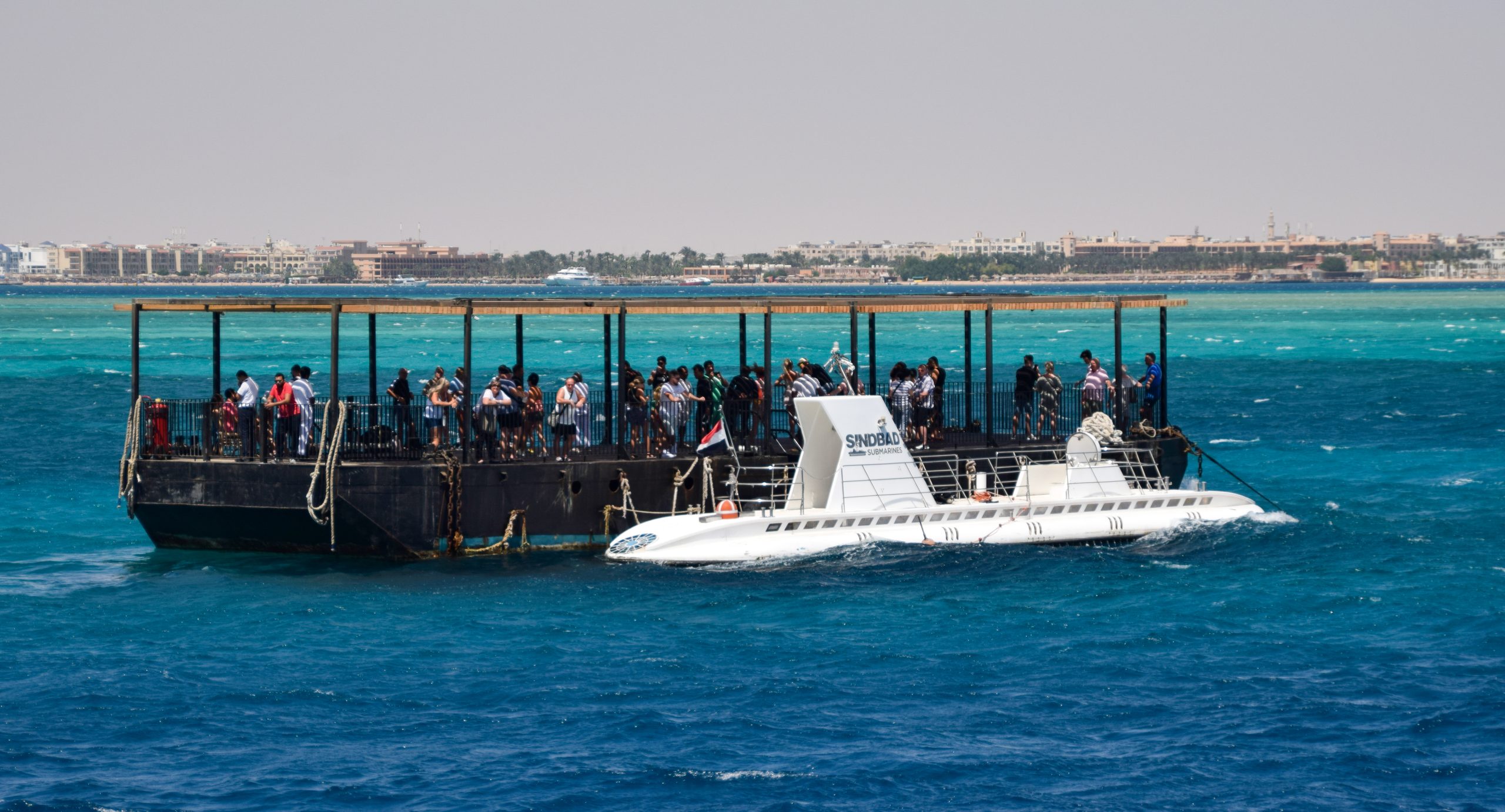 Submarino turístico de pasajeros a flote con su plataforma de embarque