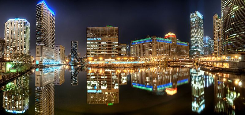 Vista nocturna del río Chicago con los rascacielos reflejados en el agua