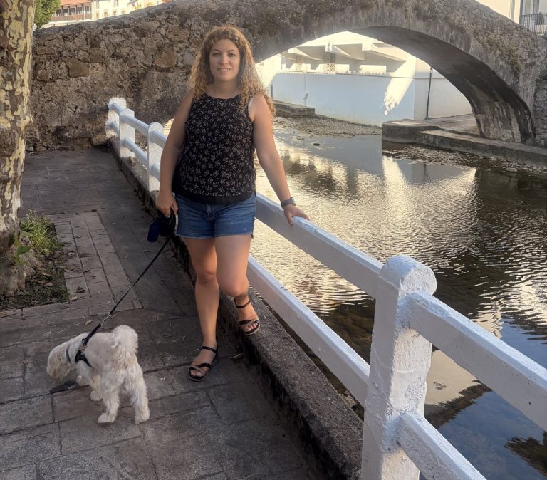 Turista y su perro posando en el puente medieval de piedra de Ea, Bizkaia