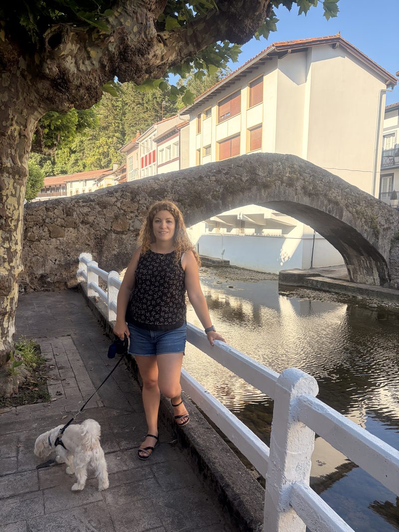 Puente medieval de piedra sobre la ría a su paso por Ea, con casas típicas vascas al fondo