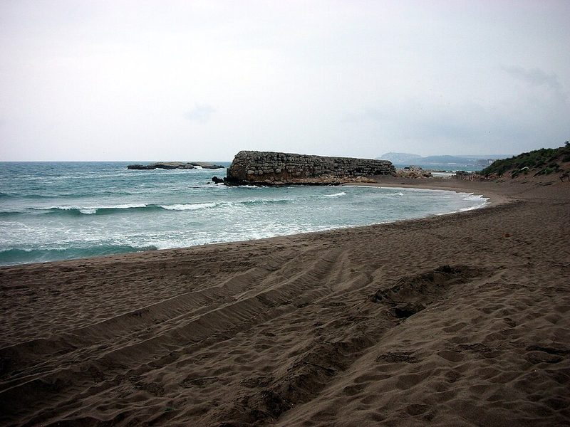 Playa del Moll Grec con el espigón antiguo, junto a las ruinas de Empúries