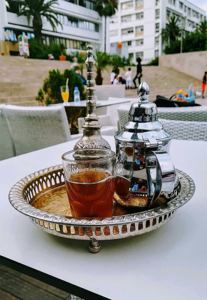 Té con menta marroquí servido en tetera y vaso tradicionales