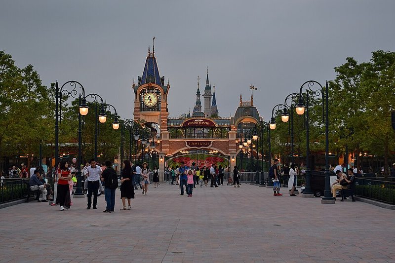 Visitantes en la avenida de entrada de Disneyland Shanghai con el castillo al fondo