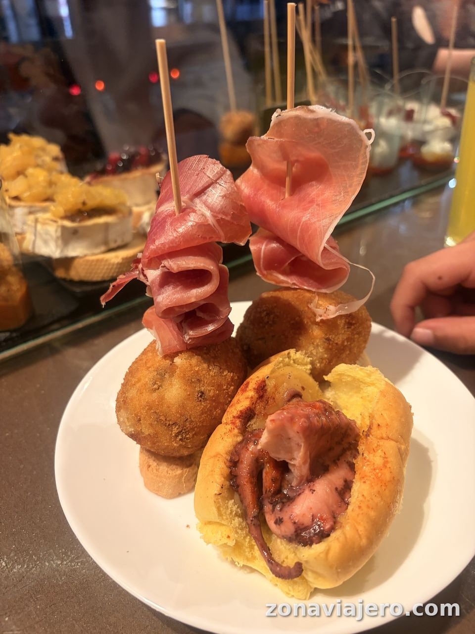 Pinchos de croqueta con jamón y bollito de pulpo en la barra de un bar de Logroño