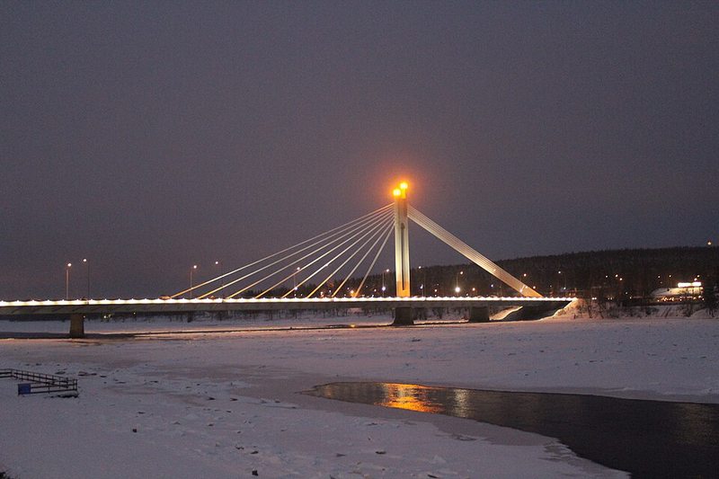 Puente Jätkänkynttilä iluminado sobre el río Kemijoki en Rovaniemi en invierno